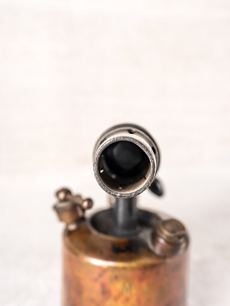 Vintage French blowtorch by Vesta F.J. Paris circa 1920, aged patina and wear, neutral backdrop.