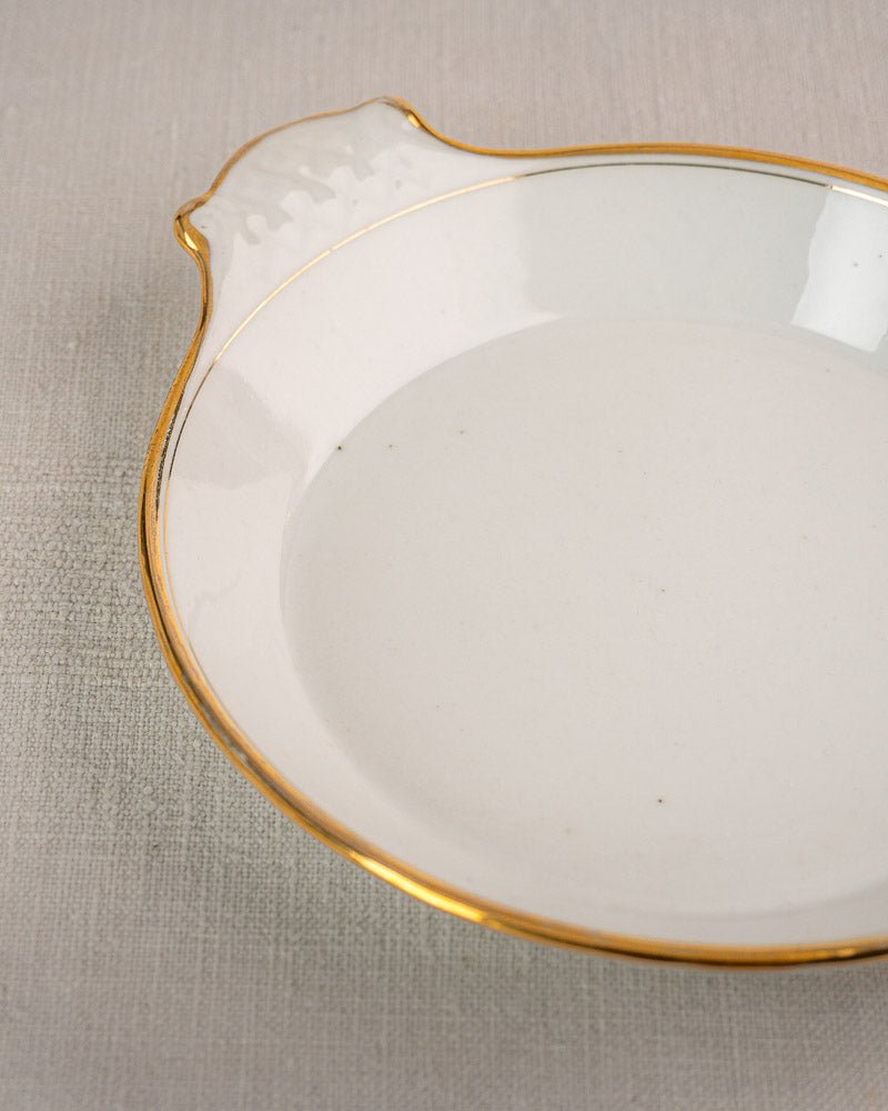 Set of three 19th-century French Vieux Paris porcelain serving dishes with gold rims on gray textured surface.