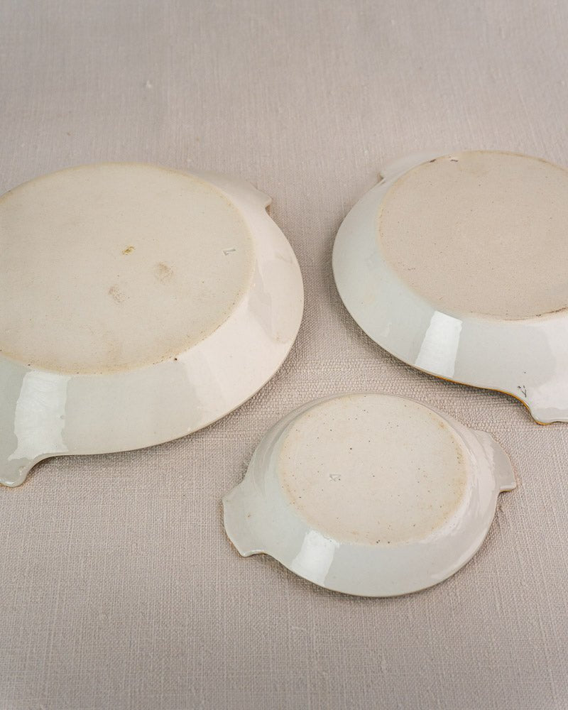 Set of three 19th-century French Vieux Paris porcelain serving dishes with elegant side handles on fabric.