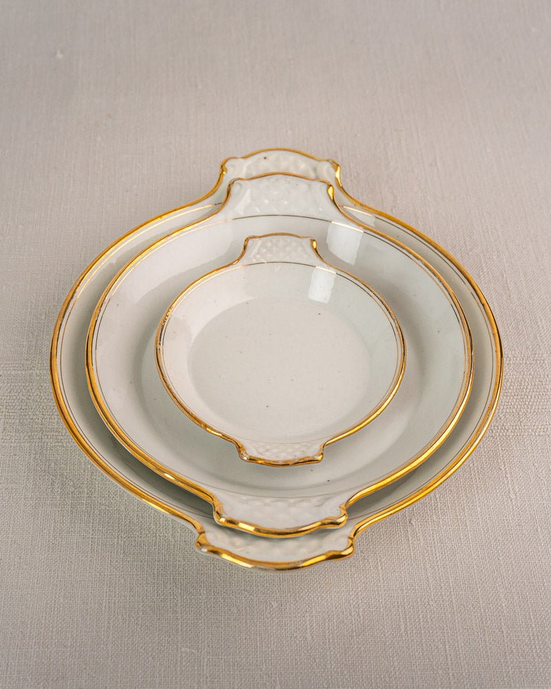 Set of three 19th-century French Vieux Paris porcelain serving dishes with gold trim and decorative handles.