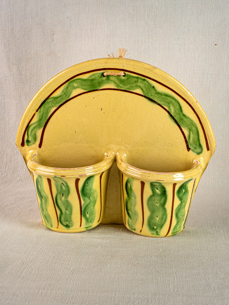 Vintage French Cliousclat terre vernissée cutlery holder with yellow glaze, wavy accents, rope loop; fabric background.