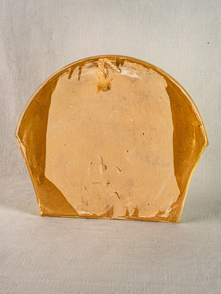 Vintage French Cliousclat cutlery holder in glossy tan terre vernissée, half-circle shape, subtle imperfections; neutral fabric backdrop.