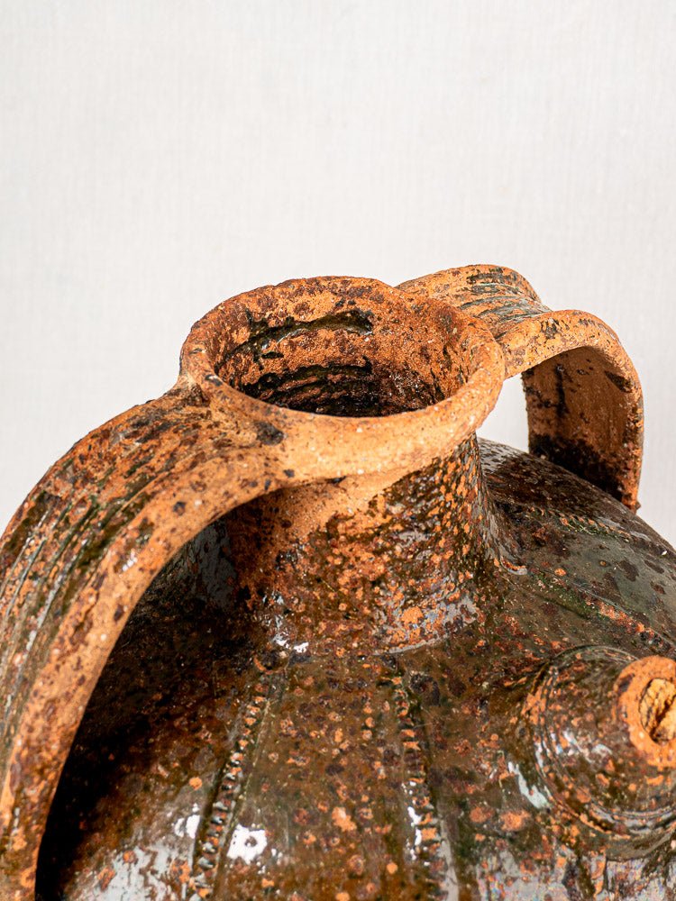 Antique French terracotta cruche with wide mouth, curved handle, and earthy green-brown glaze.