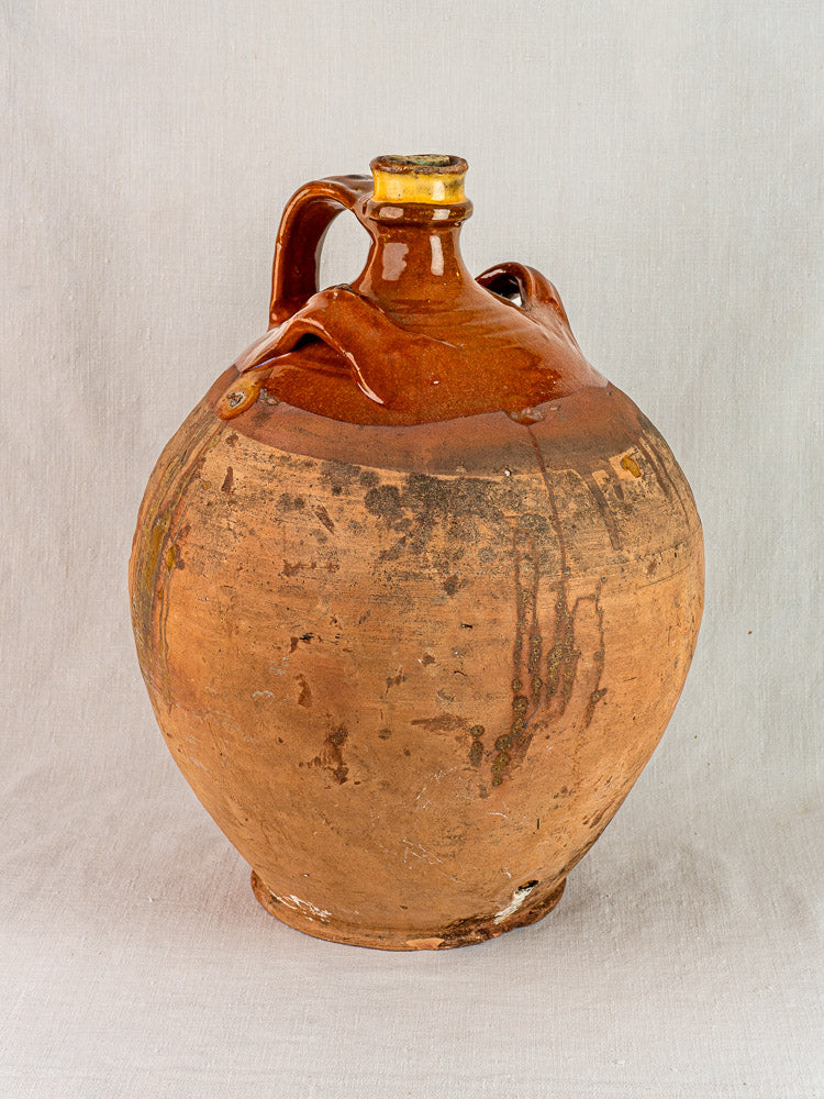 Antique French walnut oil jar in Auvergne terracotta with original cork and rustic matte glaze.