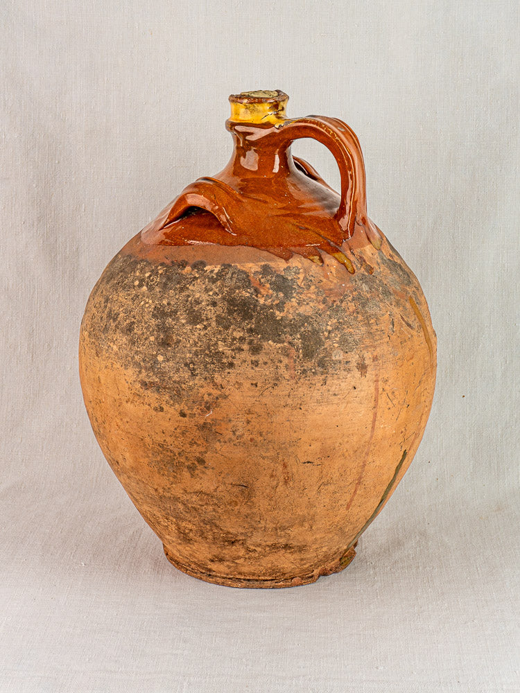 Antique French walnut oil jar in terracotta with original cork and rustic glazed upper section.