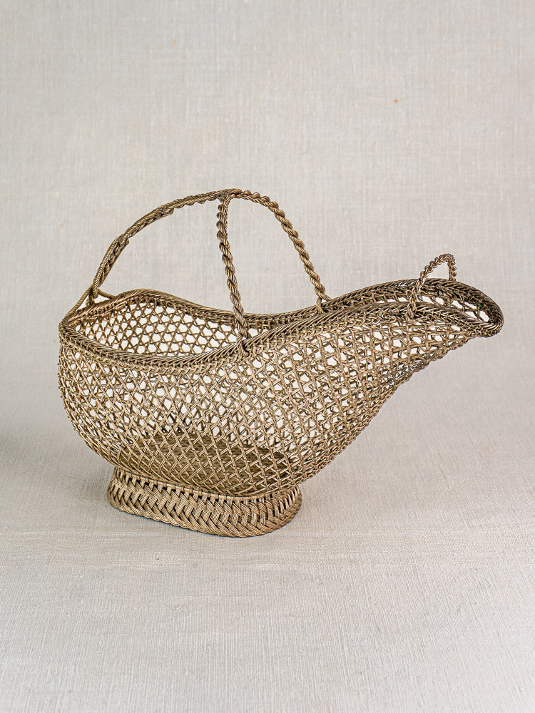 Antique French silver plate wirework wine bottle holder with curved spout and tall handle on light surface.