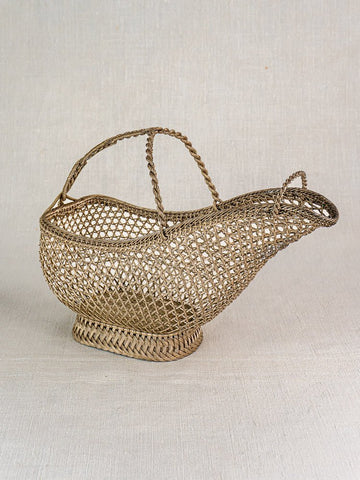 Antique French silver plate wirework wine bottle holder with curved spout and tall handle on light surface.
