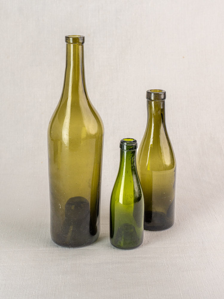 Set of three antique French hand blown olive green wine bottles, mid 19th century.