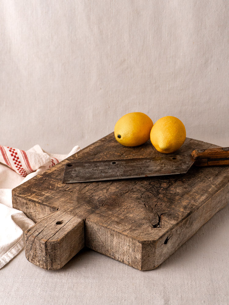 Antique French solid wood bread board with handle, late 19th-century, worn patina and knife marks.