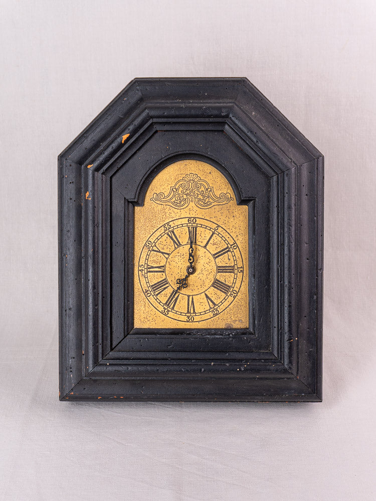 Antique French black wood wall clock with gold face, ornate detail, circa late 19th century.