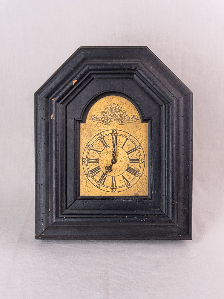Antique French black wood wall clock with gold face, ornate detail, circa late 19th century.