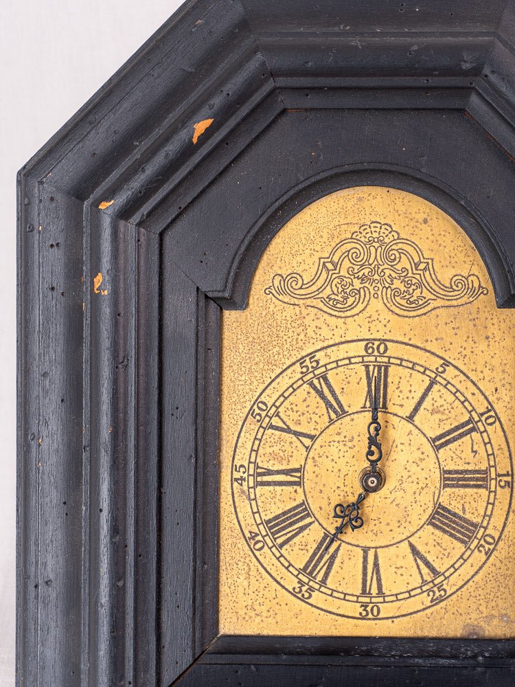 Antique French wall clock, late 19th century, black painted wood, ornate details, Roman numerals.