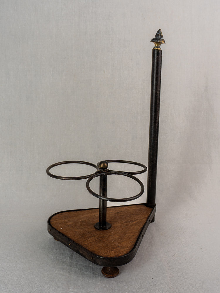 Antique French wrought iron and wood bottle carrier with three rings and a triangular wooden base.