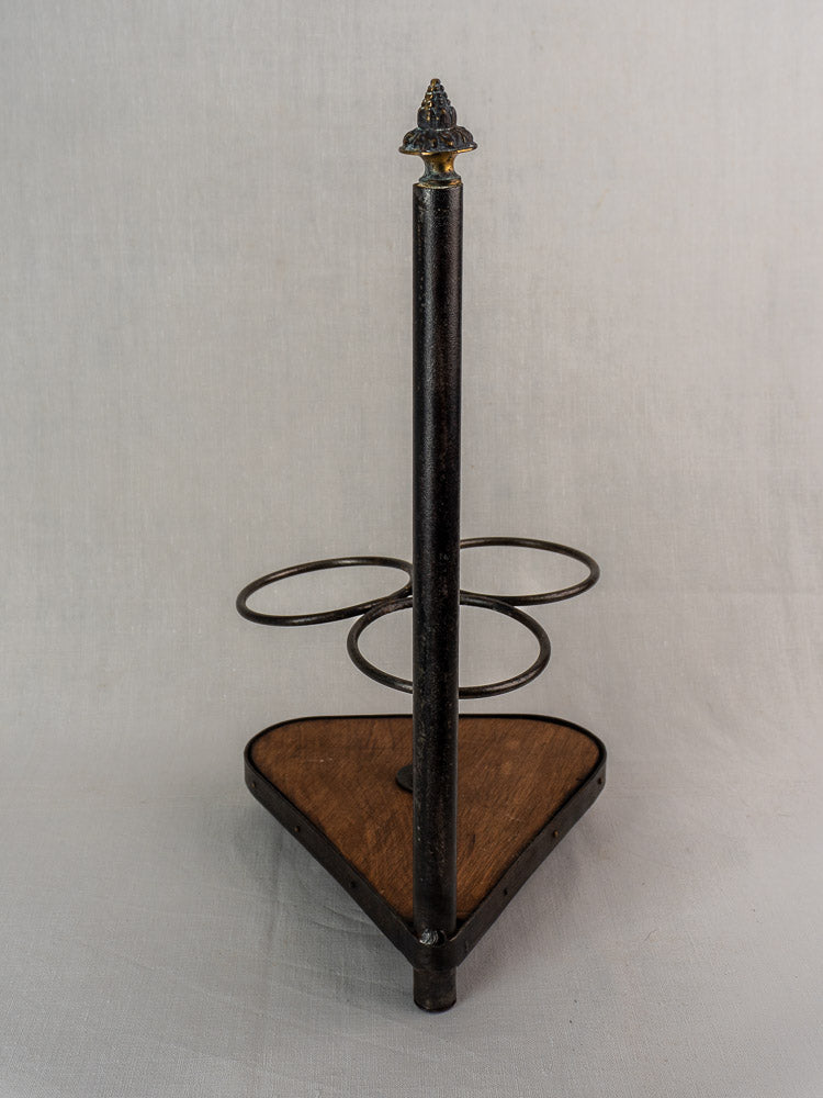 Antique French bottle carrier with triangular wood base, wrought iron holders, and decorative finial.