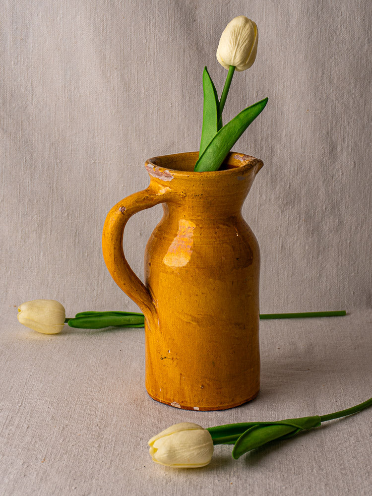 19th-century French Pichet Jaune terracotta pitcher with yellow glaze and single handle, chipped rim.