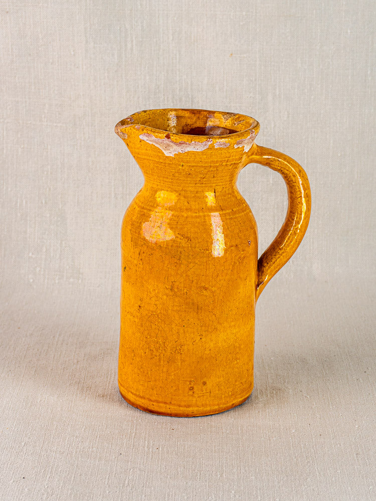 19th-century French Pichet Jaune terracotta pitcher with yellow glaze and single handle, chipped rim.