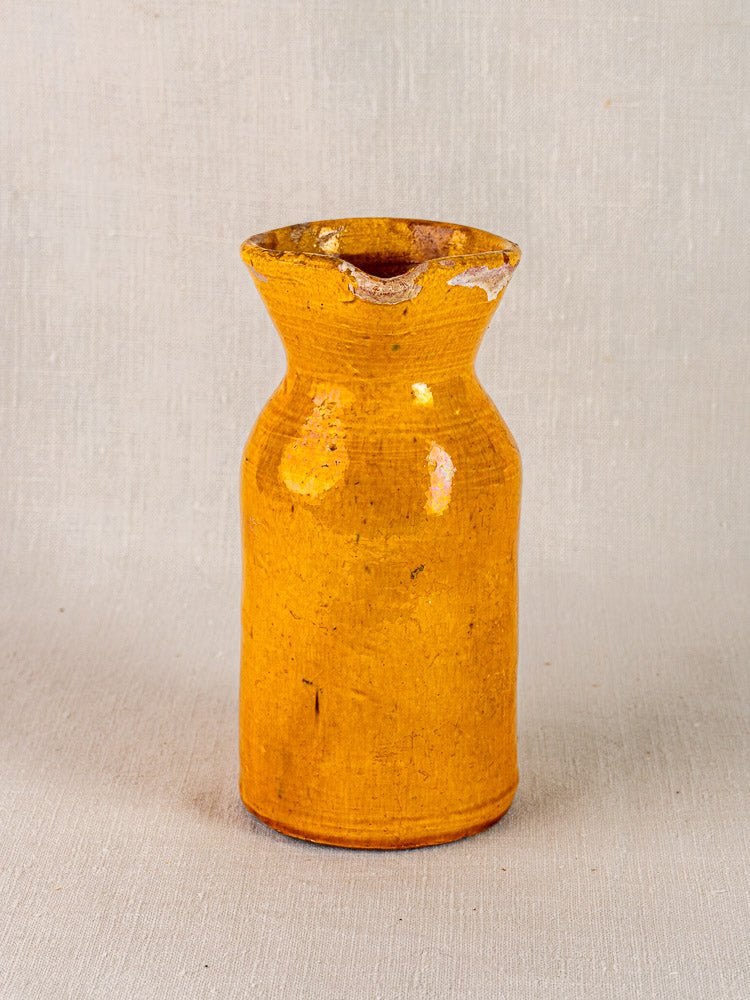 Antique French yellow glazed terracotta pichet with narrow neck, wide base, and chipped rim.