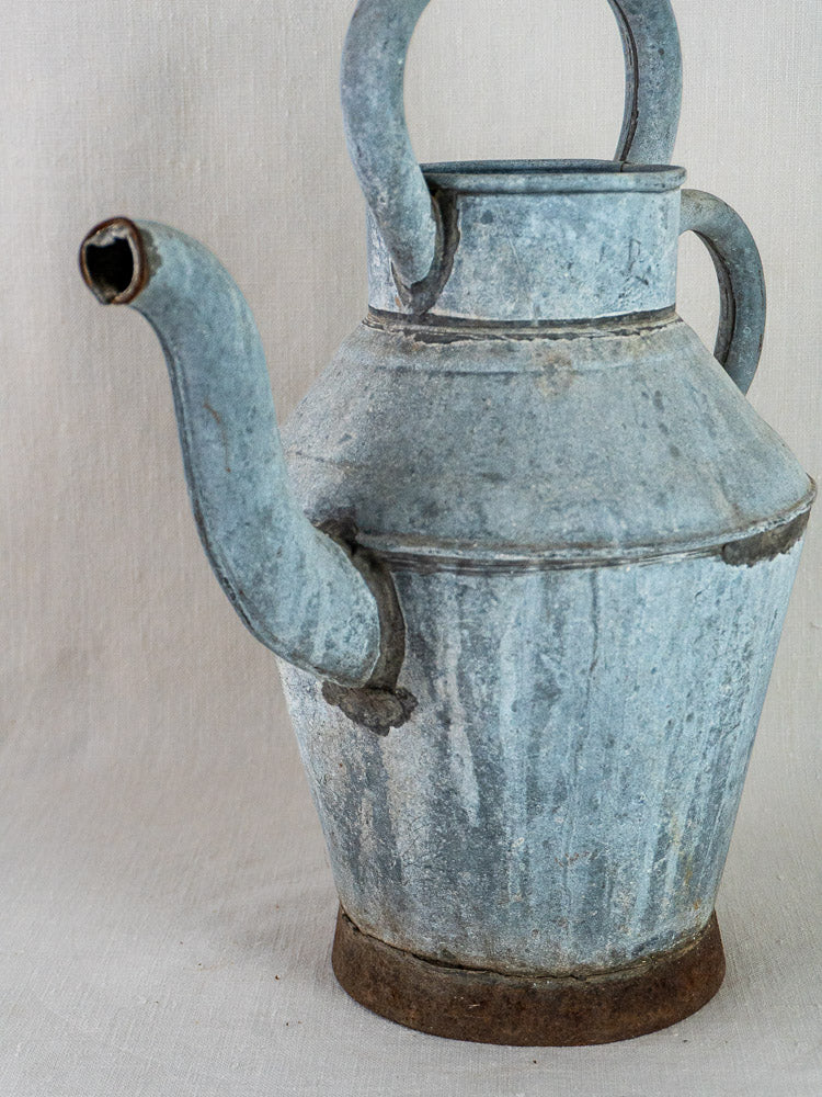 French antique zinc water pitcher with blue-gray patina and rustic accents on neutral background.