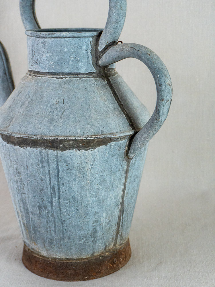French Zinc Broc à Eau antique water pitcher with blue-gray patina, twin handles, and rusty base.