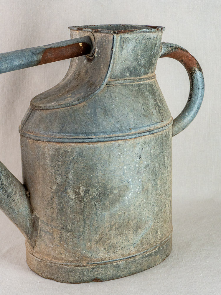 French antique zinc market garden arrosoir watering can with curved handle and aged patina.