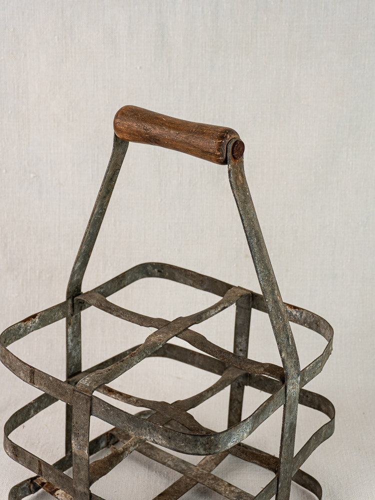 Antique French zinc and wood four-bottle wine carrier with grid design and wooden handle.