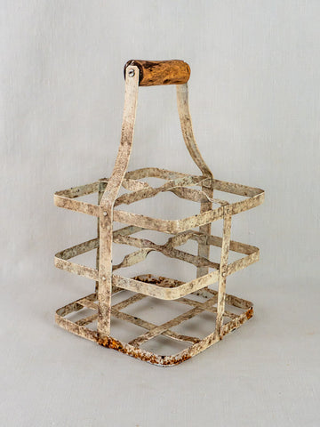 Antique French painted zinc wine carrier with wooden handle, four-bottle porte-bouteilles on light gray background.