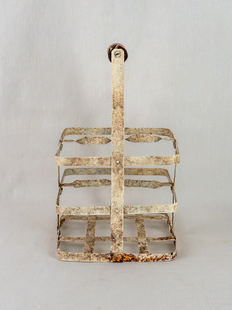 Antique French painted zinc wine carrier with four square compartments, visible rust, and sturdy handle.