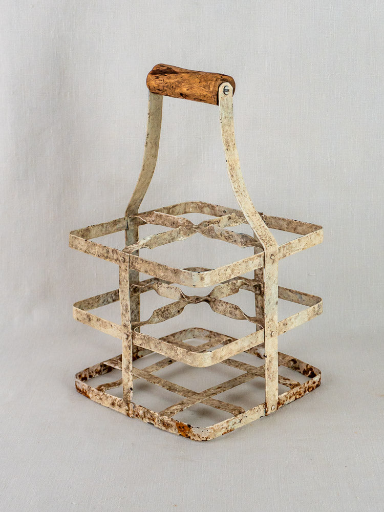 Antique French painted zinc wine carrier with four compartments, weathered white finish, rust accents, and wooden handle.
