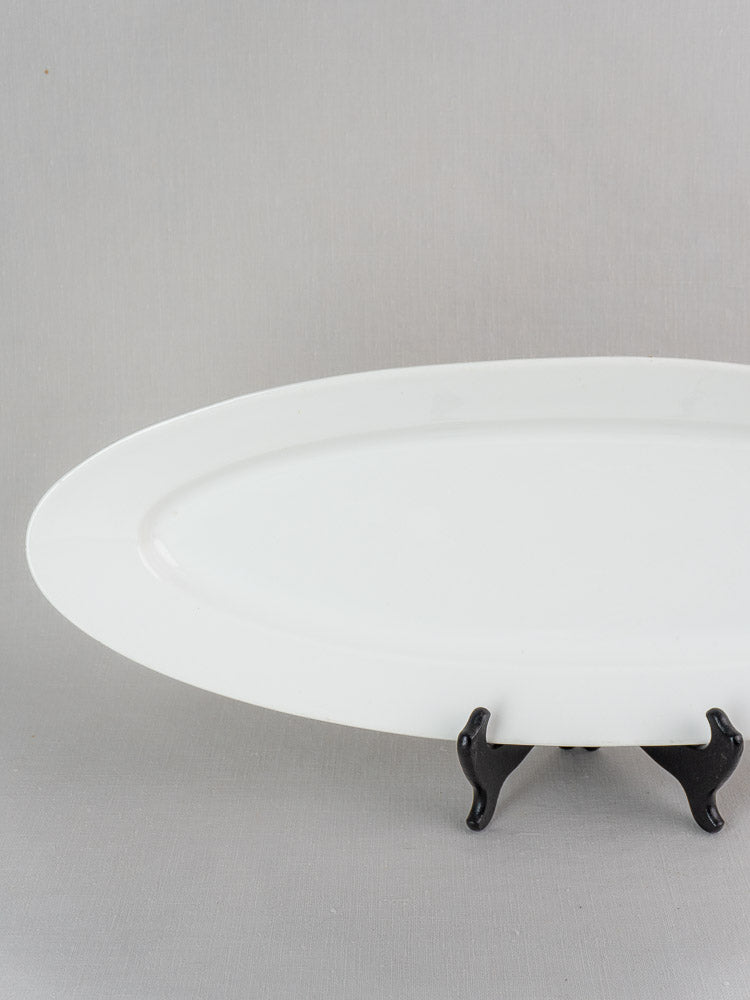 19th century French white ironstone fish platter, Turbot Platter, on black stand, light gray background.