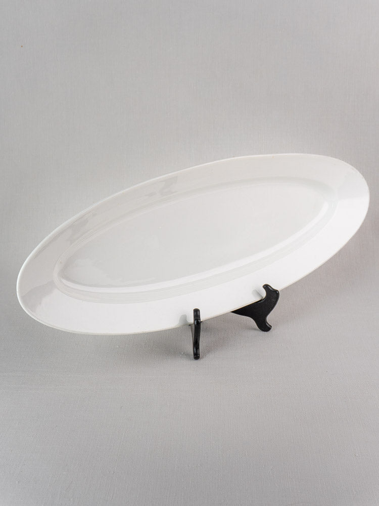 19th century French white ironstone turbot platter displayed upright on a black stand.