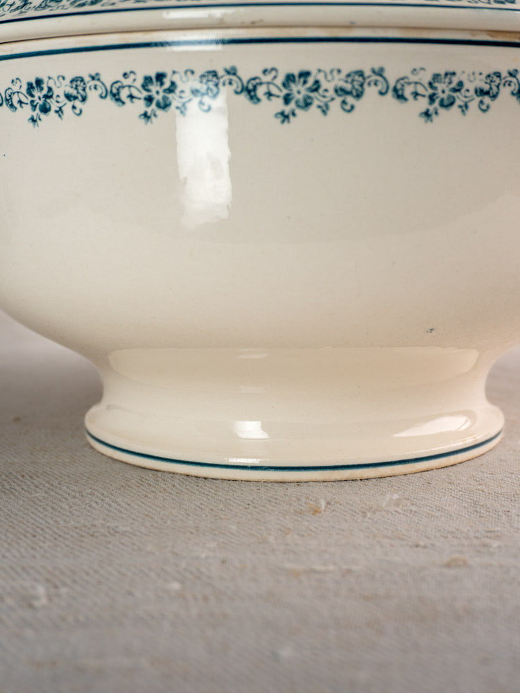 Antique French Longwy ironstone soup tureen base with cream ceramic, Capucine Blue border, on textured fabric.