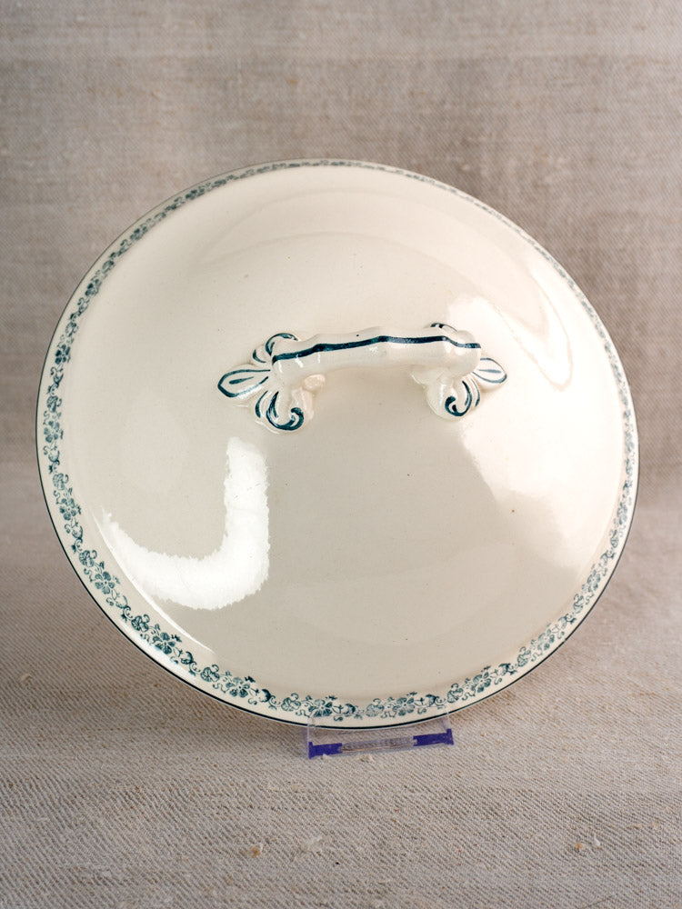 Antique French Longwy ironstone tureen lid with Capucine blue floral transferware on display stand.