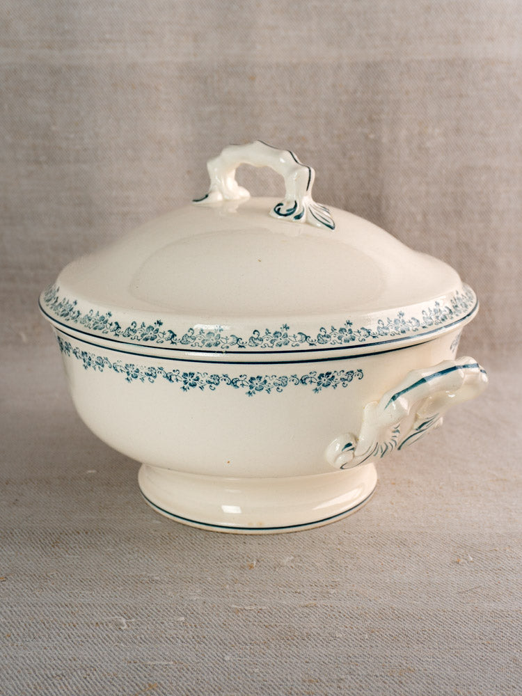 Antique French Longwy ironstone soup tureen with lid, ornate handles, and blue floral border.