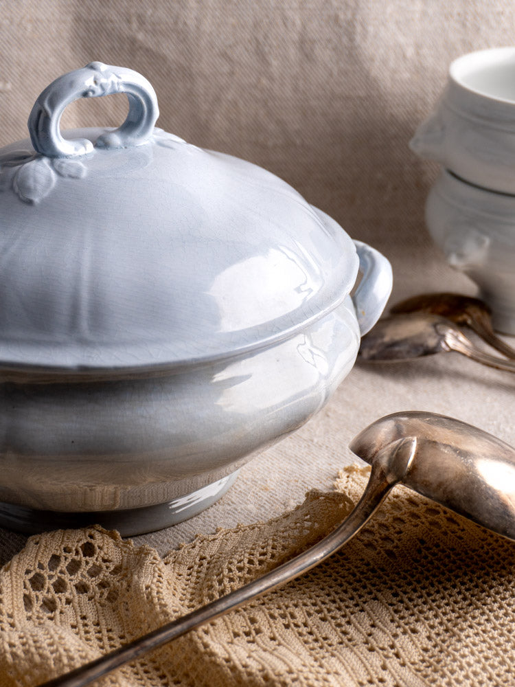 Antique Mettlach tureen by Villeroy and Boch with blue glaze and matching lid, on crocheted cloth.