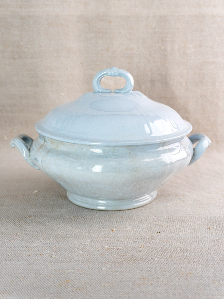 Antique Villeroy & Boch Mettlach tureen with blue glaze and ornate lid on beige fabric.
