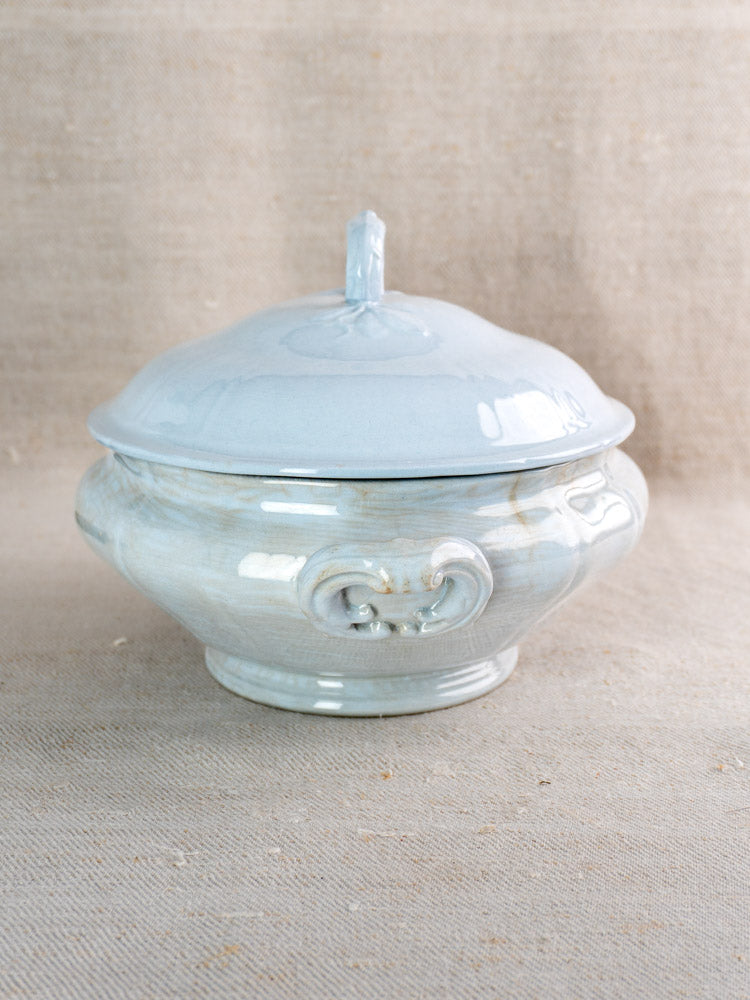 Antique Mettlach Villeroy and Boch tureen with soft blue glaze and scrolls on beige fabric.
