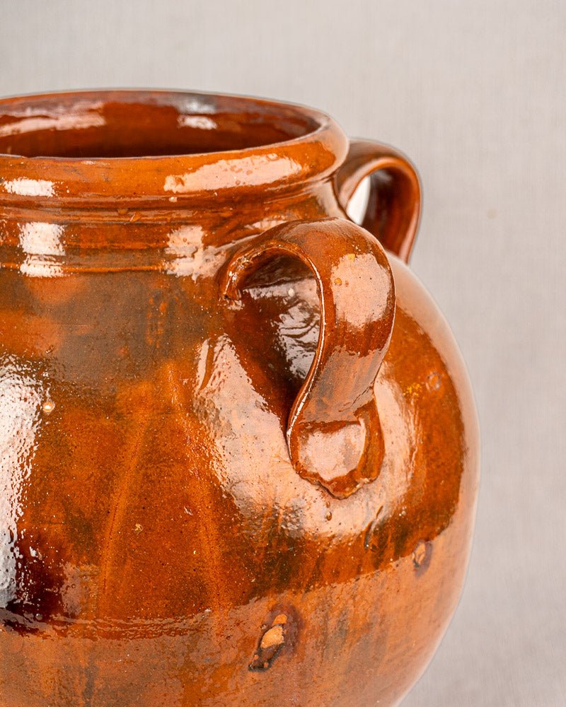 Antique French Provencal oil jar, 19th century glazed terracotta, shiny brown with two handles, on light gray background.