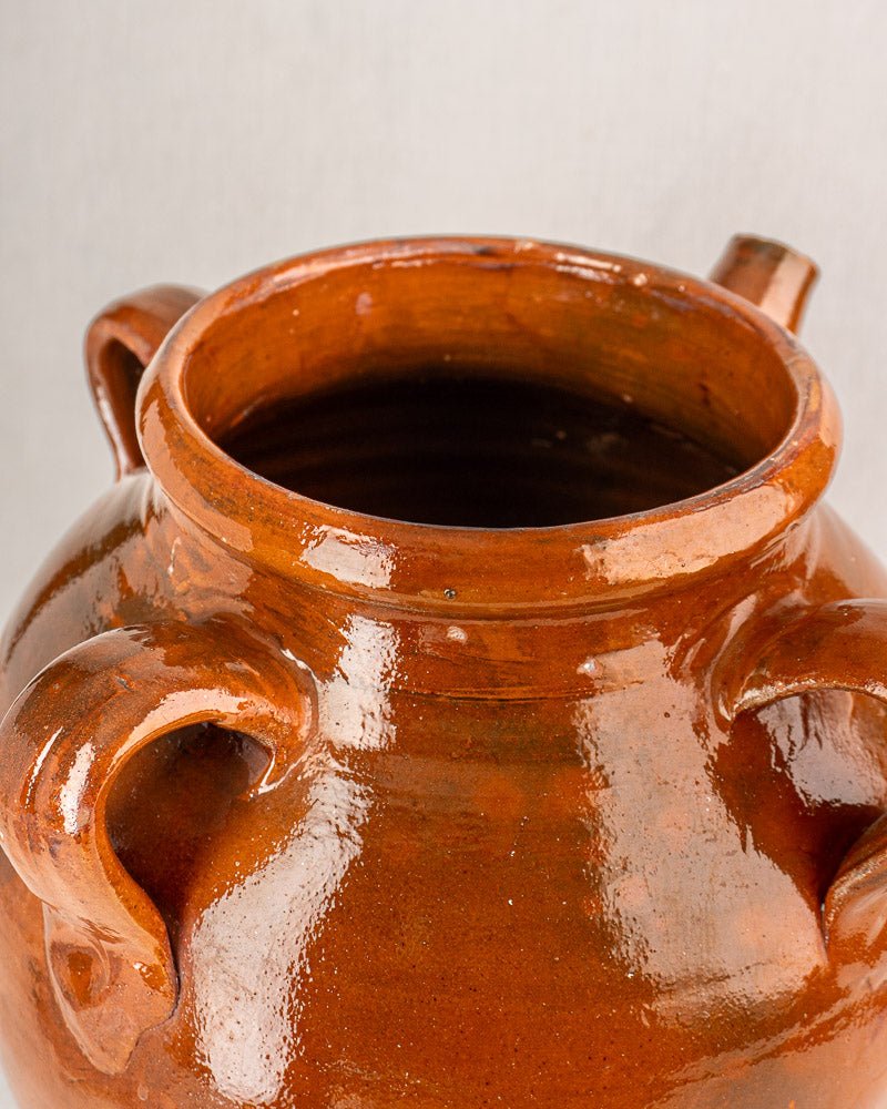 Antique French oil jar with glazed brown finish, dual handles, and short spout on light background.