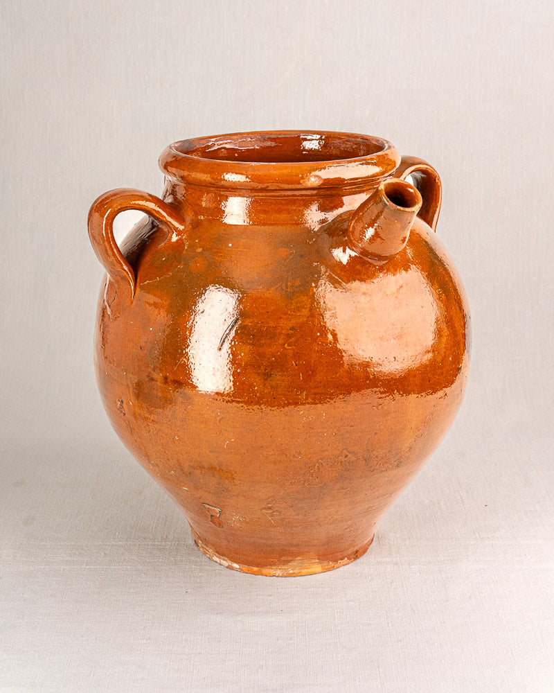 19th-century French terracotta oil jar with glossy brown glaze, round body, handles, and spout.