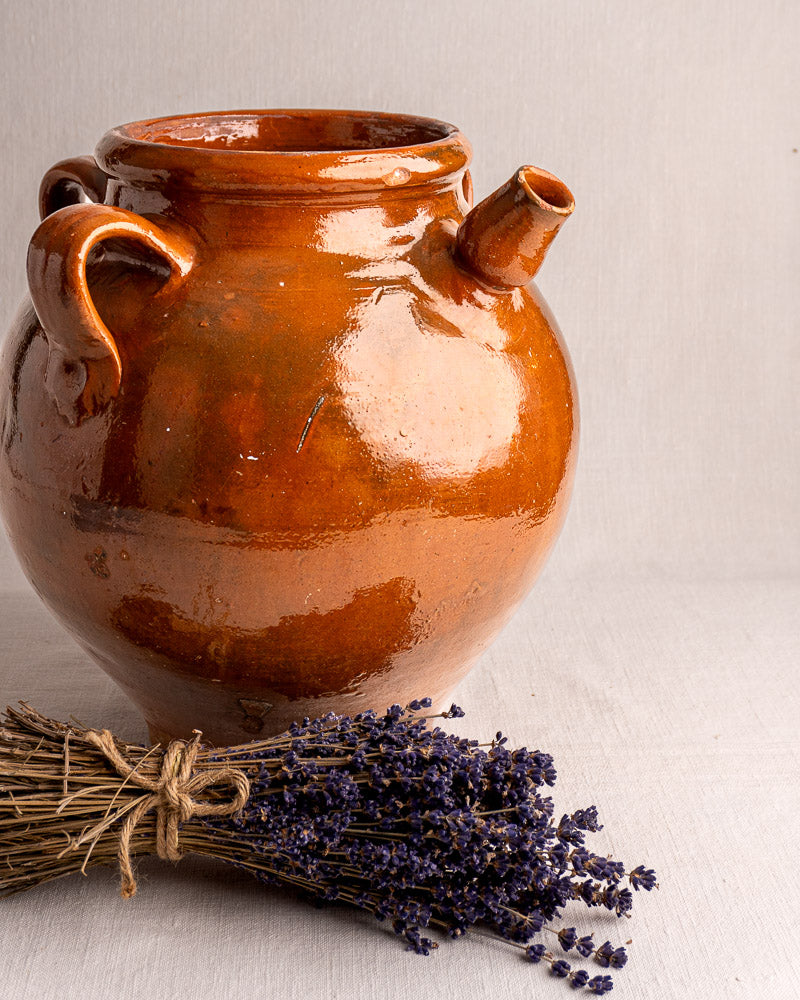 19th-century French terracotta oil jar with glossy brown glaze, round body, handles, and spout.