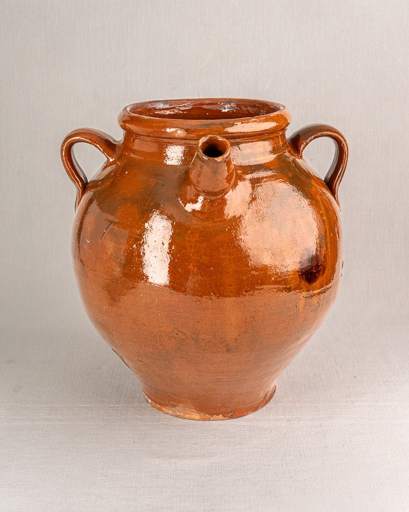 19th-century French Provencal oil jar, brown-glazed terracotta with side handles and front spout.