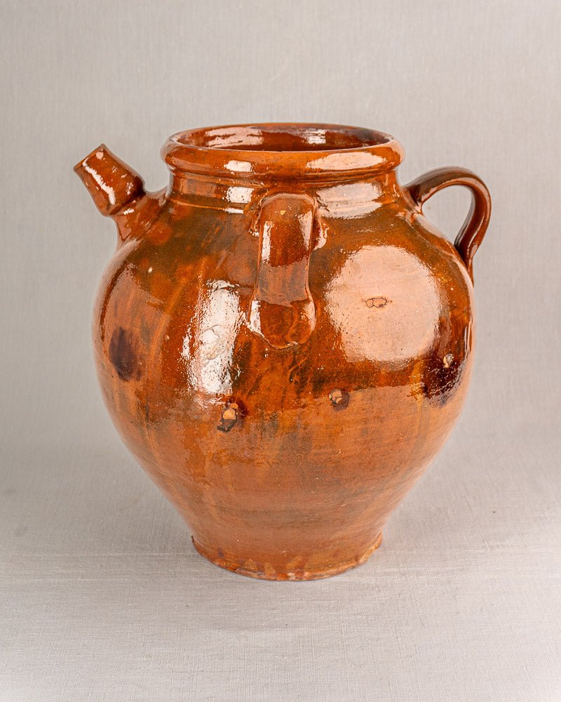 Antique French oil jar in brown-glazed terracotta with handle, wide mouth, and angled spout.