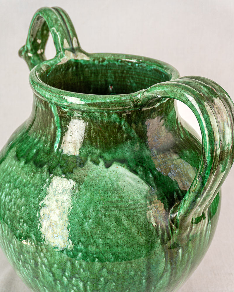 Antique French green glazed earthenware cruche with two handles and wide opening, textured mottled surface.