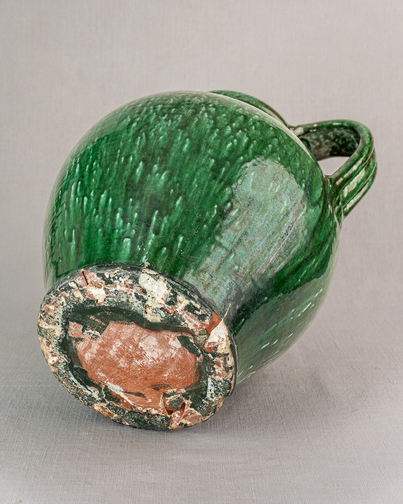 19th-century French green glazed earthenware cruche with textured terracotta, single handle, and chipped unglazed base.