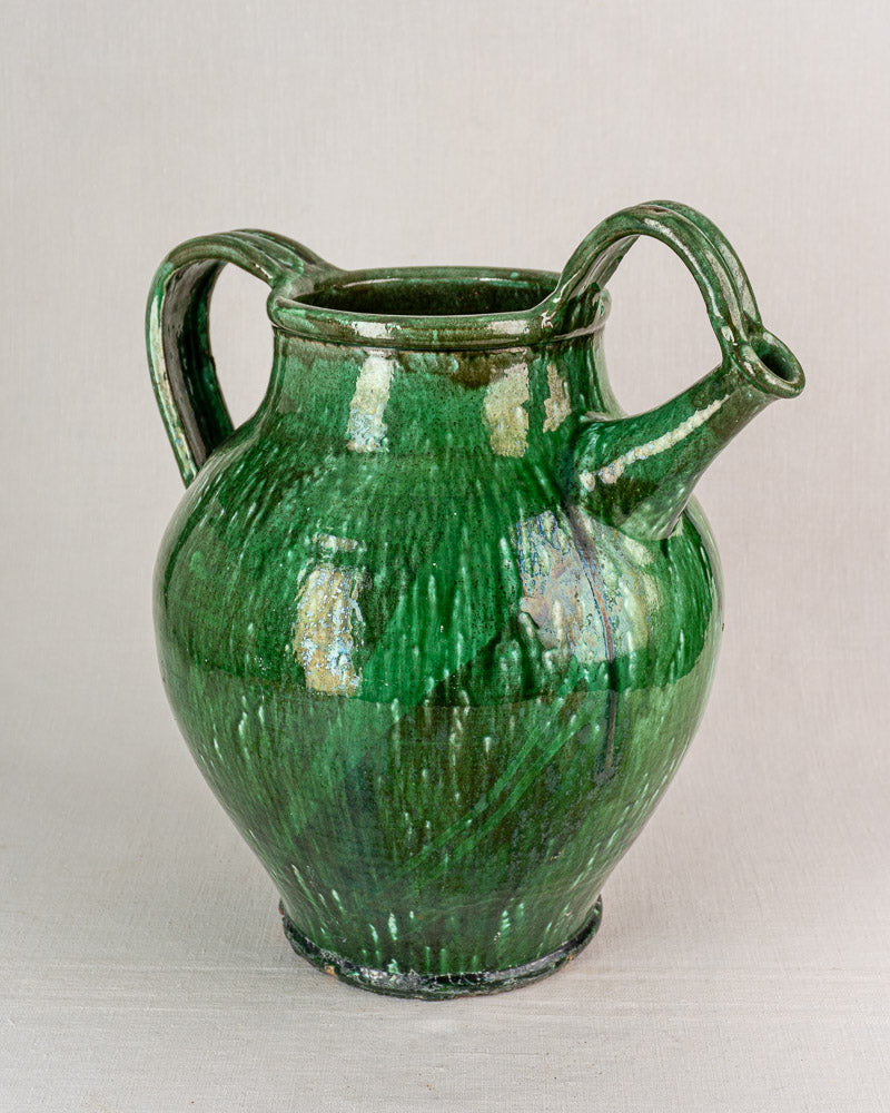 19th-century French antique cruche in green glazed earthenware with rounded body, curved handles, and side spout.