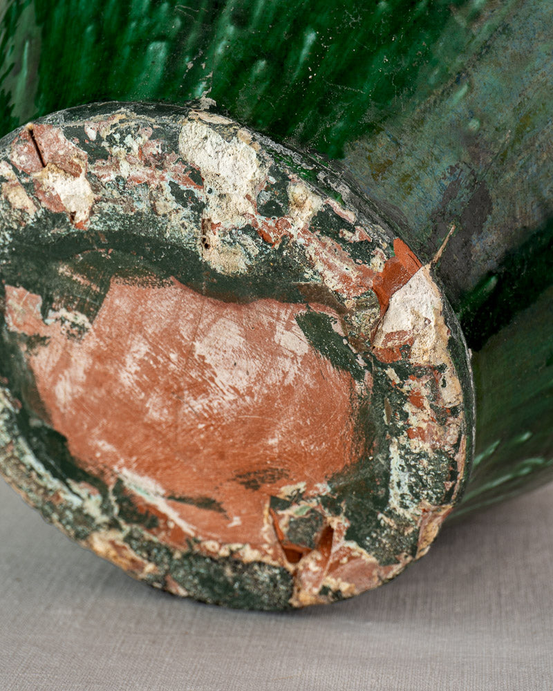 Antique French green glazed earthenware cruche base with exposed reddish clay and chipped glaze, 19th century.