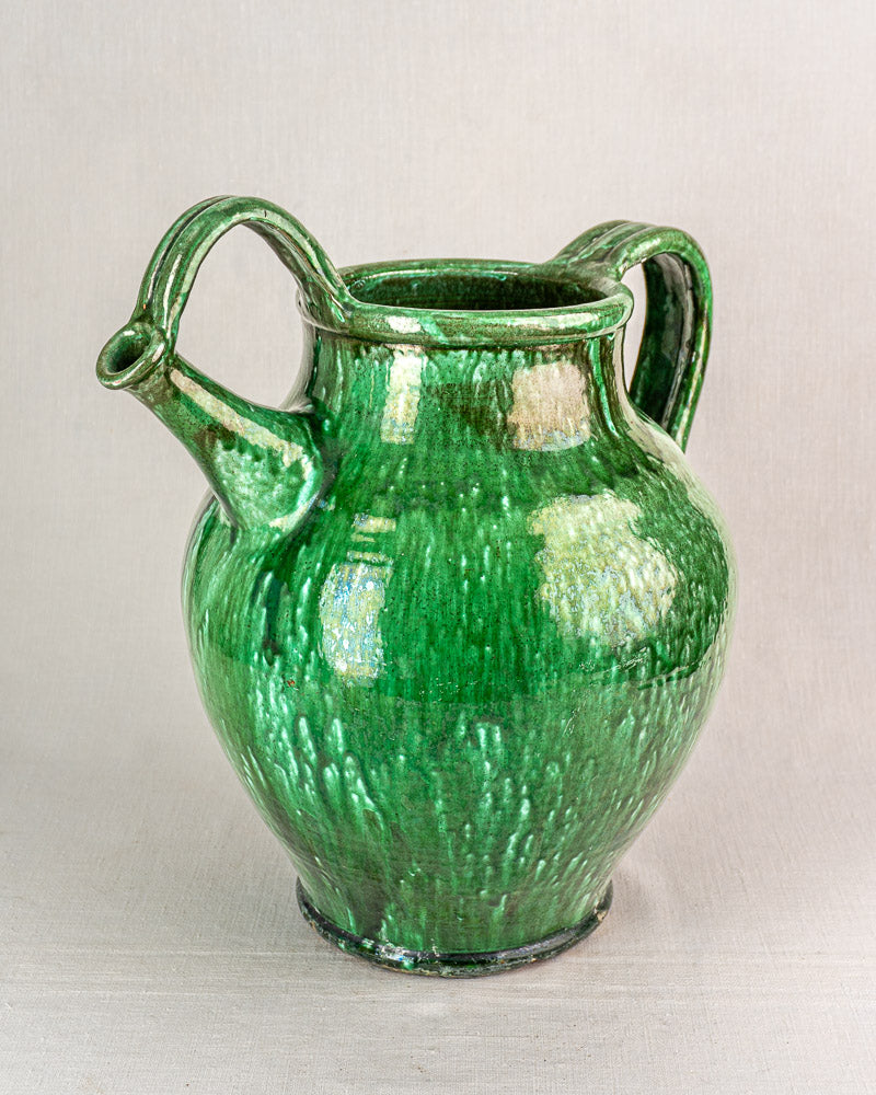 19th-century French green glazed earthenware cruche jug with two curved handles and wide rounded body on neutral background.