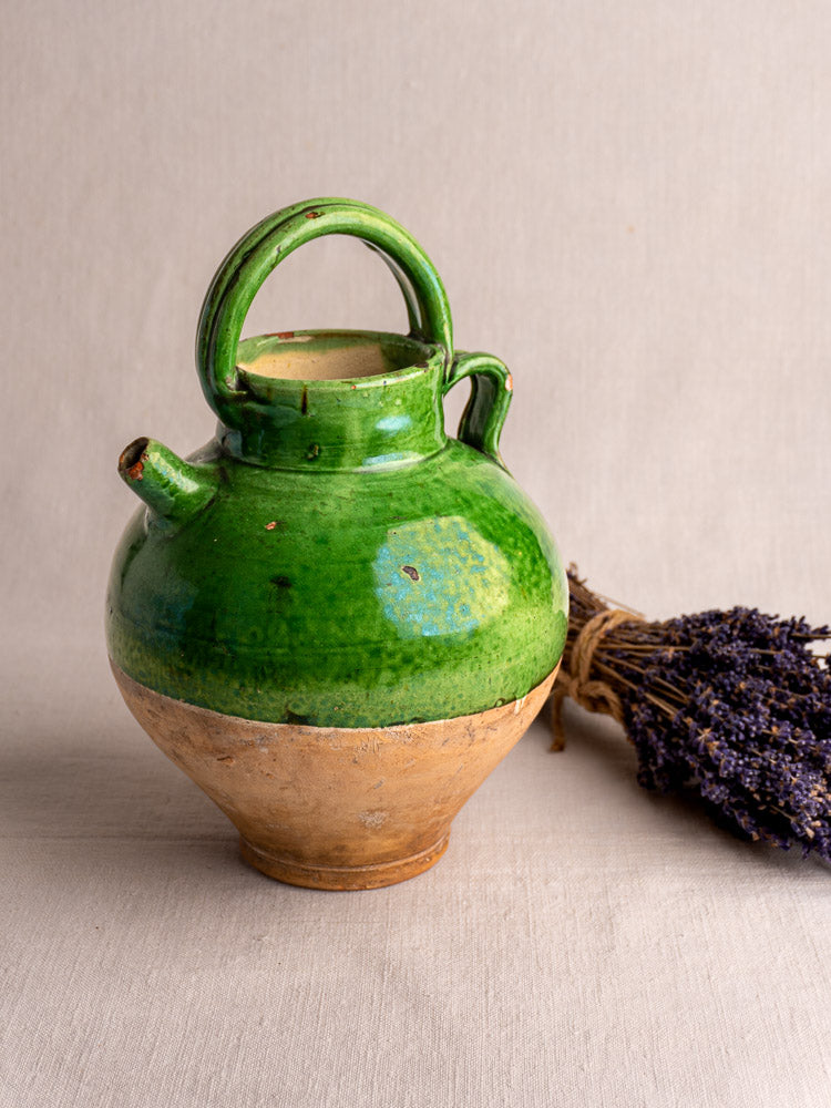 Antique French Provençal gargoulette water cruche with green glazed terracotta top and clay base, dried lavender beside it.