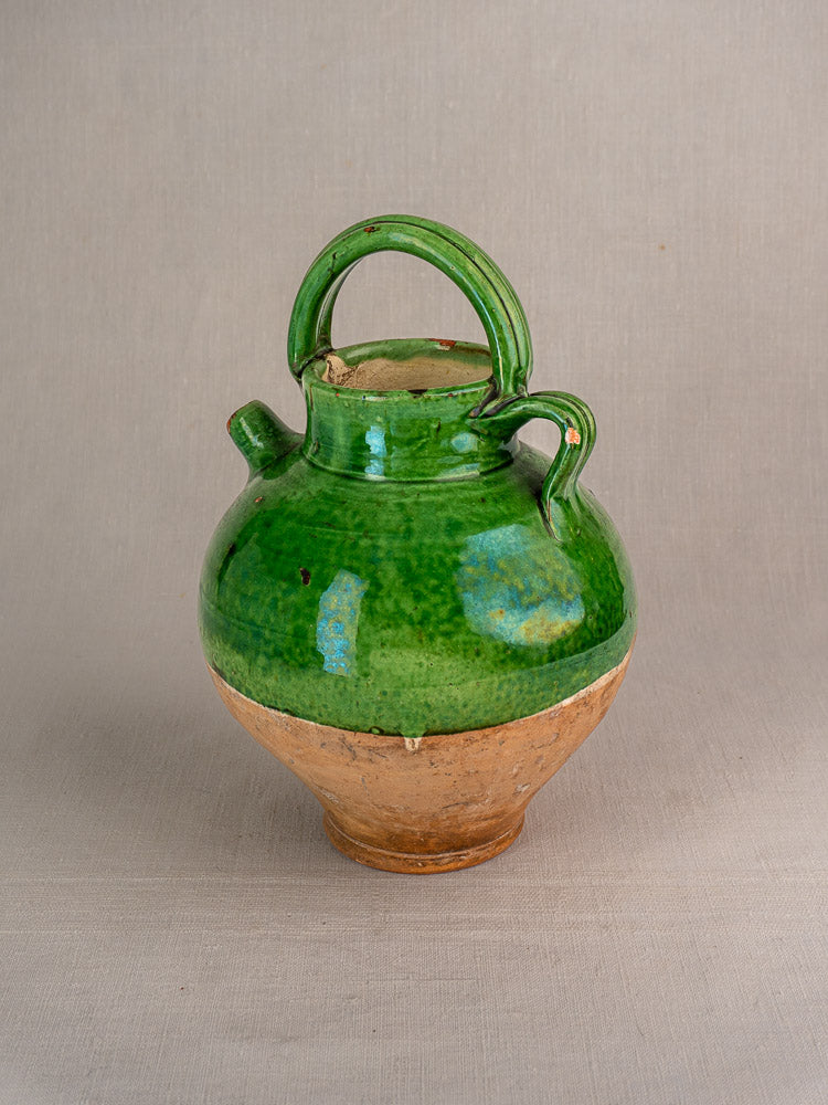 Antique French green glazed terracotta gargoulette water cruche with rounded body on light gray background.