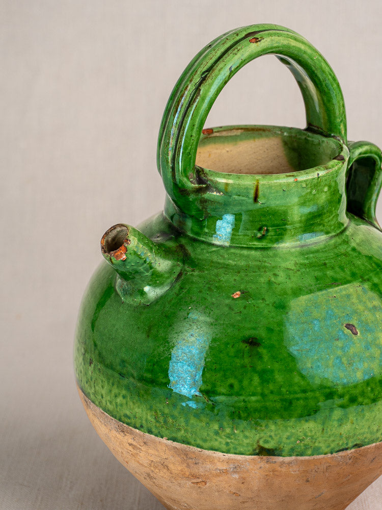 Antique French green glazed terracotta gargoulette water cruche with handle, spout, and unglazed clay base.